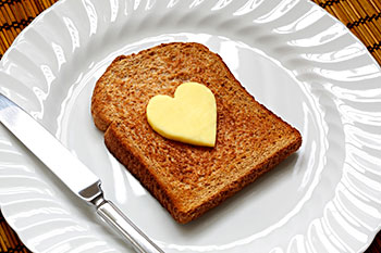a piece of toast topped with a pat of butter in the shape of a heart