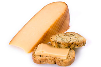 A larger wedge of gouda cheese and a small portion served on a crouton