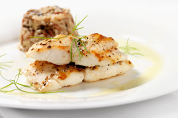 two cooked filets of cod garnished with sprigs of dill