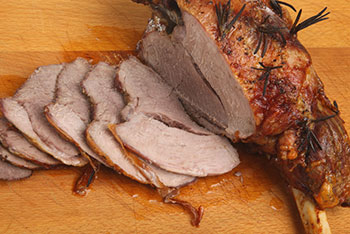 a roasted leg of lamb with slices cut from it