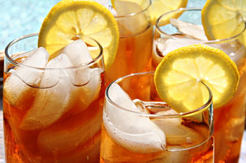 Several glasses of iced tea garnished with lemon