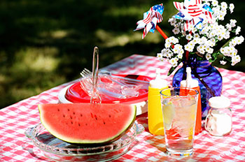 Fourth of July Table with watermelon, mustard and ketchup, and a floral centerpiece