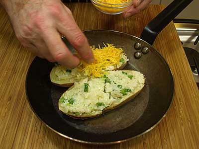 Place the stuffed halves in a pan and top with the cheddar cheese.
