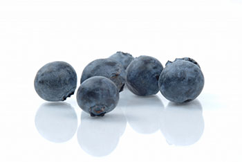 a closeup of a half-dozen blueberries against a white background