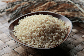 uncooked short-grain brown rice in a wooden bowl