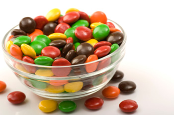 a clear glass bowl full of M&M-like candies