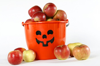a bucket decorated like a jack o'lantern filled with apples