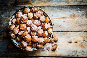 a bowl of unshelled hazelnuts