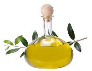Olive oil in a cruet and olive branches as background