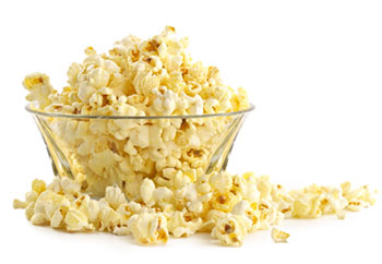 A large clear bowl overflowing with popcorn