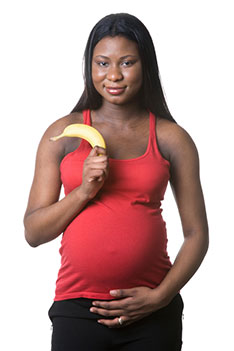 a pregnant woman holding a banana