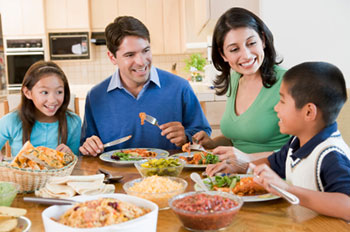 A family of four dining together in a home kitchen