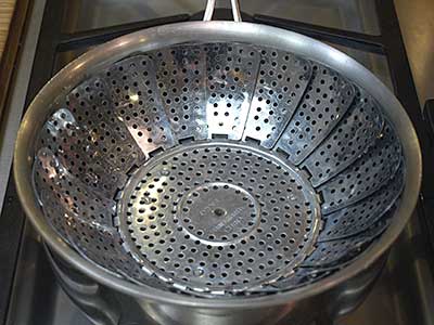 Place the water in a sauce pan fitted with a steamer basket over high heat.