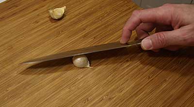 Crush the garlic under the flat of a knife