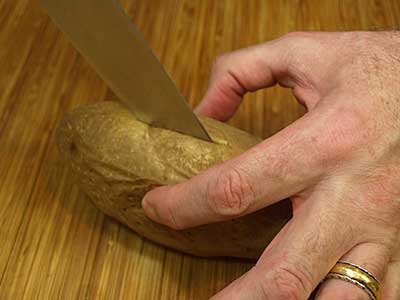 When the potato is done, let it cool for a few minutes, then cut in half.