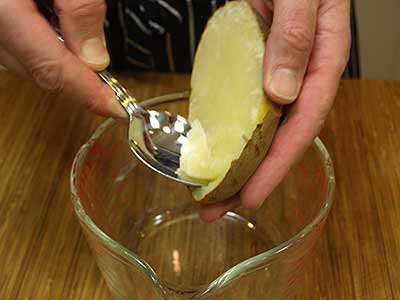 Scoop out the flesh of the potato into a bowl.