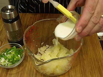 Once all the flesh is scooped out, add the buttermilk to the potato flesh.