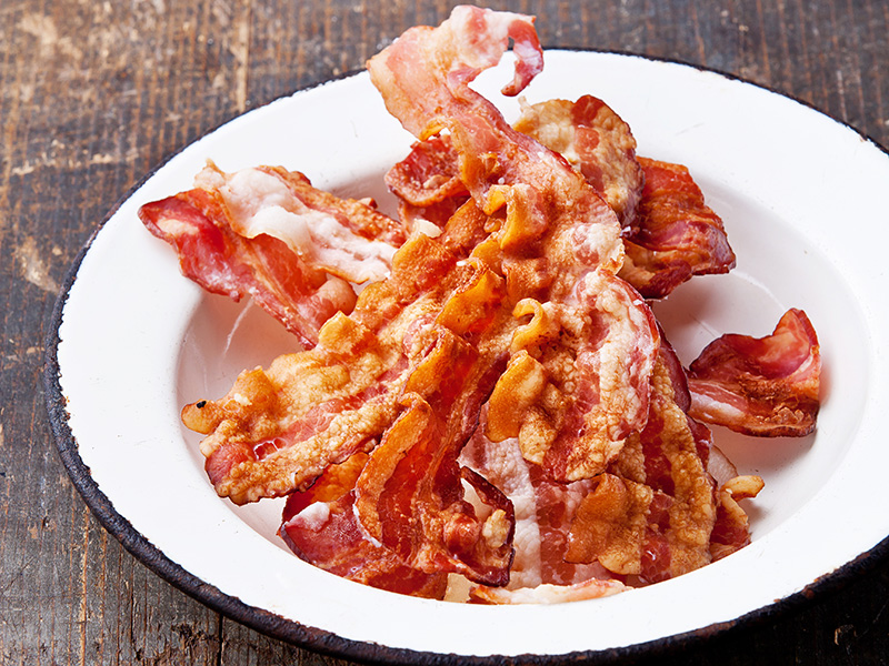 A bowl of freshly cooked bacon. Make Bacon Garlic Hash Browns with this recipe from Dr. Gourmet.