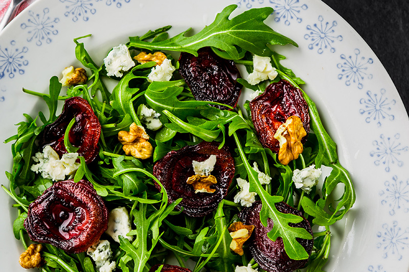 a green salad with roasted beets, arugula, pecans, and blue cheese
