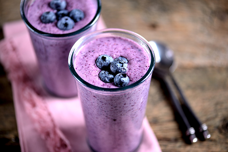 a blueberry smoothie garnished with whole fresh blueberries