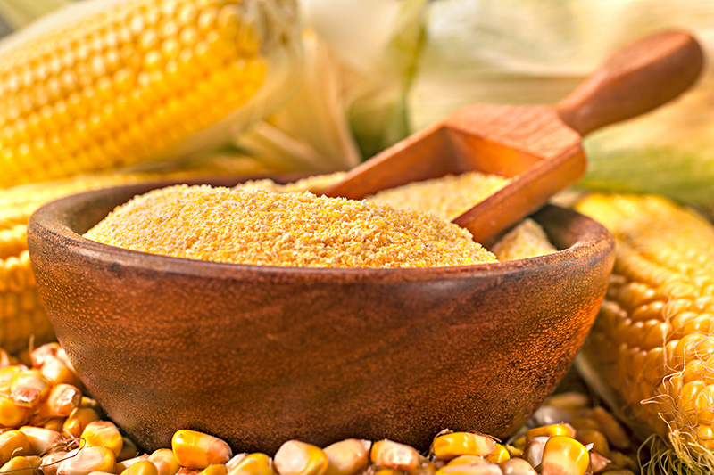 both fresh and dried corn as well as ground corn (grits) on a wooden table