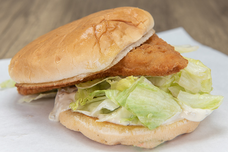 a sandwich of breaded, fried fish with lettuce and mayonnaise
