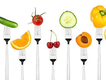 an assortment of fruits and vegetables speared on forks