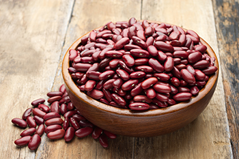 a wooden bowl full of dried kidney beans