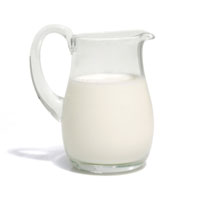 Transparent glass jug full of milk