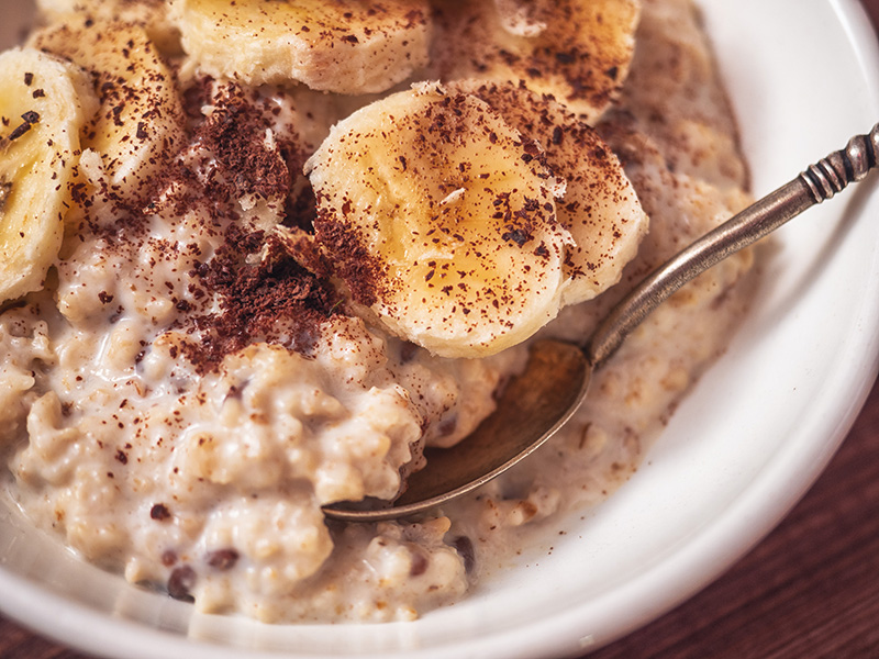 a bowl of oatmeal garnished with cinnamon and sliced bananas