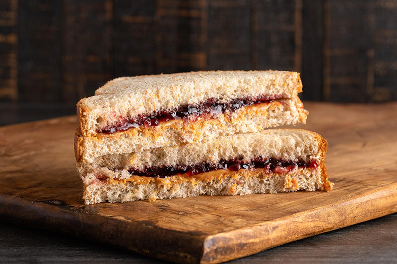 a peanut butter and jelly sandwich on whole wheat bread, sliced in half