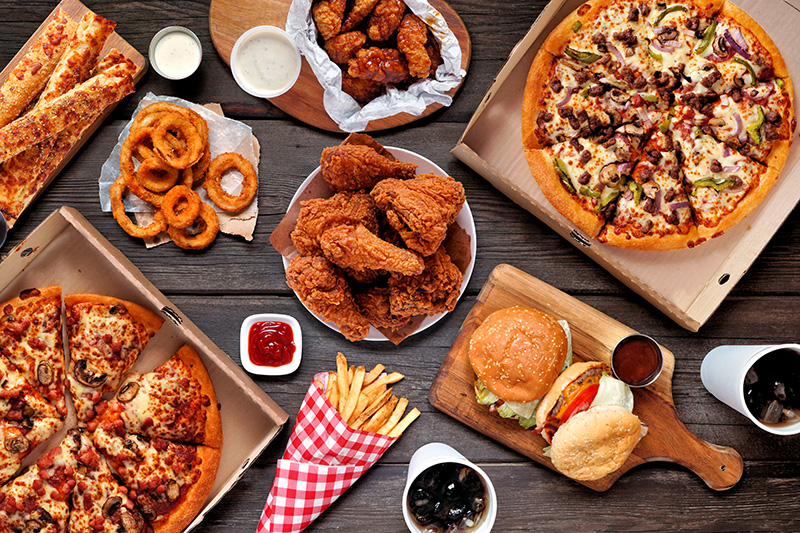 Highly processed foods, including fried chicken, pizza, french fries and onions rings, and burgers.