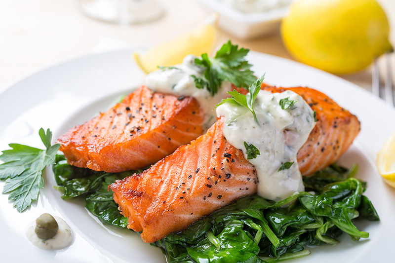 a closeup of roasted salmon steaks with a creamy sauce
