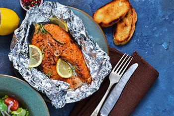 Salmon cooked in a pouch of aluminum foil