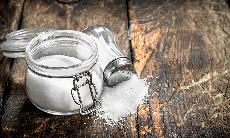 salt in a clear glass jar on a wooden table