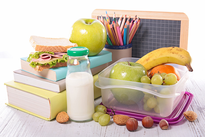 School books and a packed school lunch, with milk to drink
