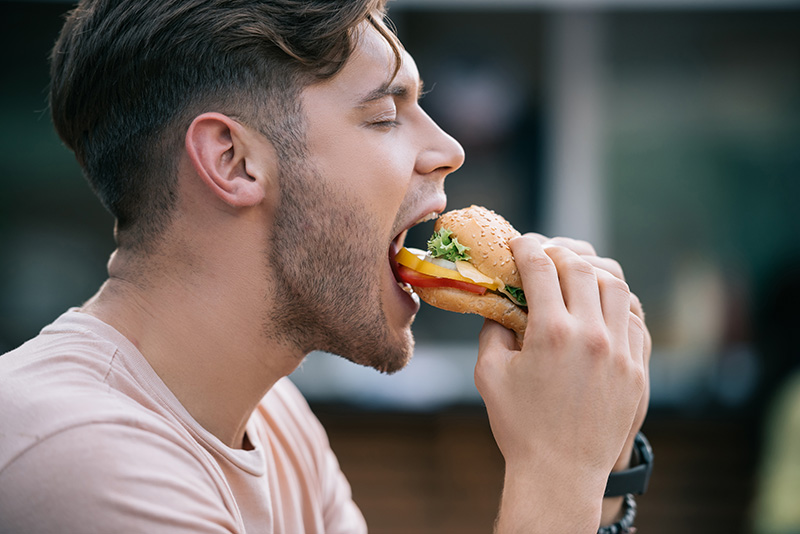 a young man eating a burger