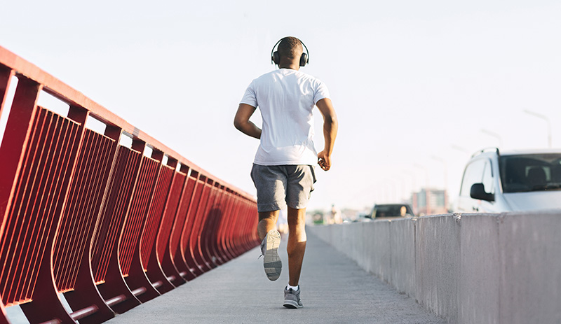 a man jogging for exercise while wearing headphones